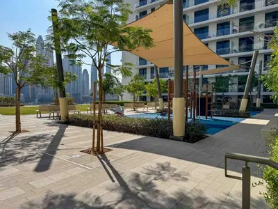 a pavilion with trees in front of a building at Frank Porter - Palace Beach Residence in Dubai