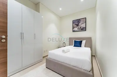 a bedroom with a bed and a sign on the wall at High-Floor Balcony with Burj Khalifa View and Assistant Room, Minutes from Burj Plaza & Dubai Mall, Easy Access to Downtown Attractions, Imperial Avenue, Downtown Dubai by Deluxe Holiday Homes in Dubai