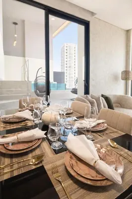 a dining room table with glasses and plates on it at Private Pool I Sleeps 6 I 5 Star Amenities I 2BR Onyx in Dubai