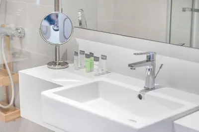 a bathroom with a white sink and a mirror at Canal Front Luxe, Elegant 2BR with Water Views in Dubai