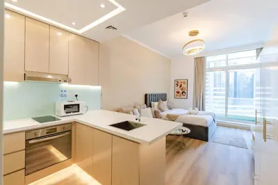 a kitchen and a living room with a couch at Sunny Studio - Dubai Marina - Close Beach in Dubai