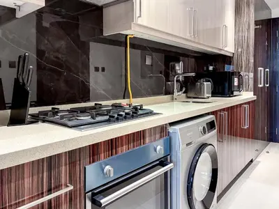 a kitchen with a stove and a washing machine at Elite Downtown Residence, Downtown Dubai - Onelink in Dubai