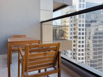 a wooden table and chair on a balcony with a view at Elite Downtown Residence, Downtown Dubai - Onelink in Dubai