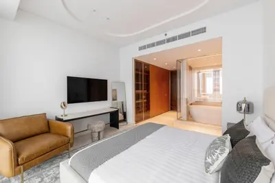 a bedroom with a bed and a couch and a television at Exclusive 2BR Residence on Palm Jumeirah - Beach Access in Dubai