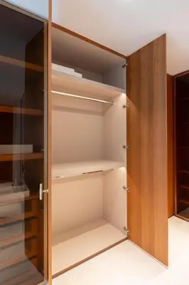 a closet with wooden doors and shelves at Exclusive 2BR Residence on Palm Jumeirah - Beach Access in Dubai