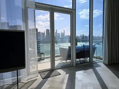 a living room with a large window with a view of the city at Top Floor Penthouse In Oceana With Panoramic Views in Dubai