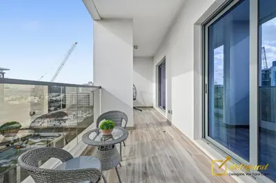 a balcony with a table and chairs on a building at Oversized 1BR Apartment Near Dubai Hills Mall in Dubai