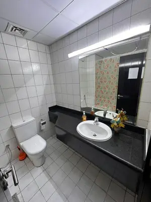a bathroom with a toilet and a sink and a mirror at Executive Master bed Room With attached bathroom in Dubai