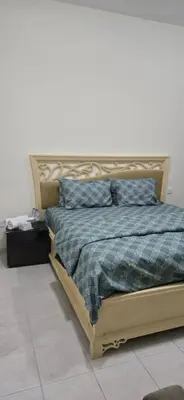 a bedroom with a bed with a blue and green comforter at Luxury Master Bed Room With Attached Bathroom in Dubai