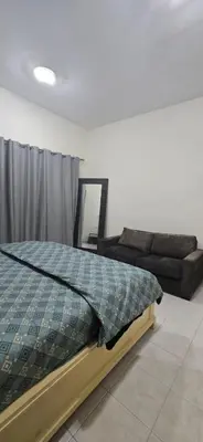 a bedroom with a bed and a couch at Luxury Master Bed Room With Attached Bathroom in Dubai