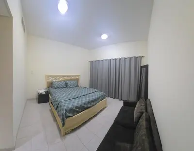 a bedroom with a bed and a couch at Luxury Master Bed Room With Attached Bathroom in Dubai