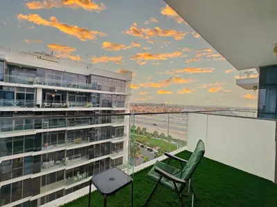 a balcony with a view of the ocean and a building at Spacious Golf & Pool View Home with Huge Balcony in Dubai