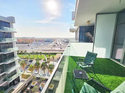 a balcony with two chairs and a view of a city at Spacious Golf & Pool View Home with Huge Balcony in Dubai