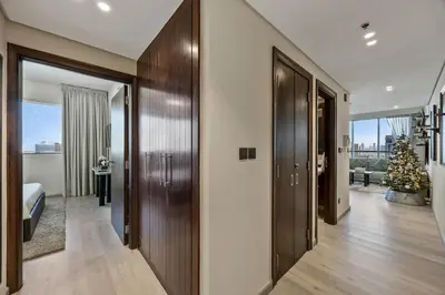 a hallway with wooden doors and a christmas tree at Nonna house Stylish 1BR and Panoramic Studio, City, Golf, Lake view in Dubai