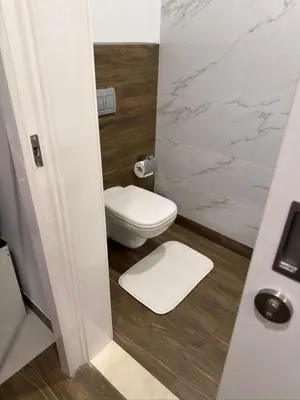 a bathroom with a white toilet and a marble wall at Luxury Stunning Burj Khalifa View High Floor Big Balcony Pool&Gym 1BR 80m2 in Dubai