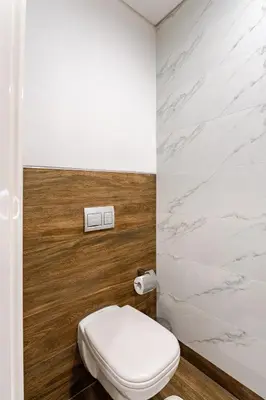 a bathroom with a white toilet and a marble wall at Luxury Stunning Burj Khalifa View High Floor Big Balcony Pool&Gym 1BR 80m2 in Dubai