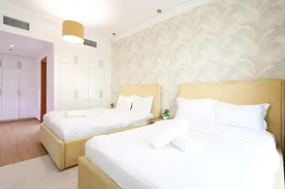 two beds in a room with white walls at Luxury 2BHK In Marina W Rooftop Pool Man 1908 in Dubai
