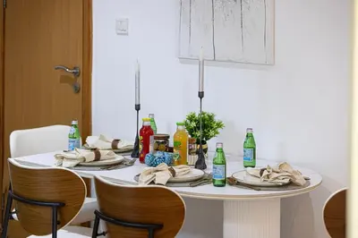 a white table with plates and bottles on it at Lux 3 Bedroom Apt In Dubai Marina Man 2003 in Dubai