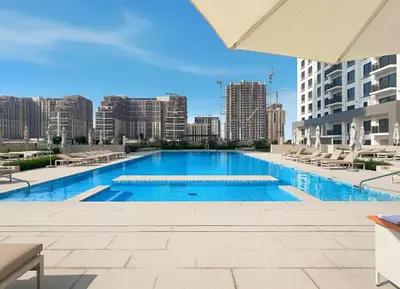 a swimming pool with a city skyline in the background at New Elegant 1BR with Balcony & Pool in Park Field in Dubai