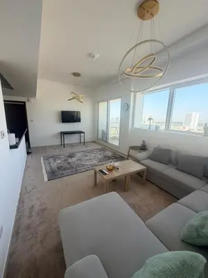 a living room with a couch and a table at Stunning Furnished 3-Bedroom Apartment in Dubai