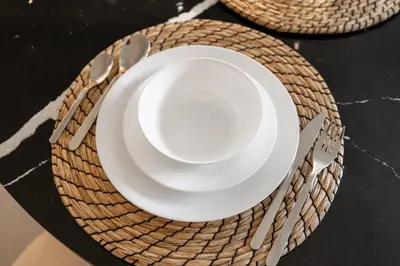 a stack of plates and utensils on a table at New! Lovely 1BR with Balcony & Pool in Binghatti Orchid in Dubai