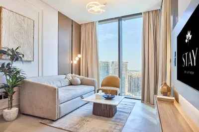 a living room with a couch and a table at STAY BY LATINEM Luxury 1BR plus study Holiday Home W2405 in Dubai