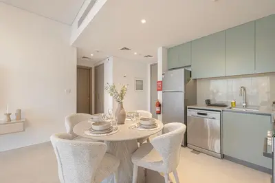 a kitchen with a table and chairs in a room at Daniels 1BR at Viridian by Central Park, City Walk in Dubai