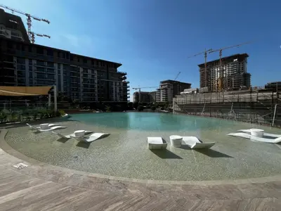 a pool of water with white chairs and buildings at Daniels 1BR at Viridian by Central Park, City Walk in Dubai