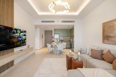 a living room with a couch and a tv and a table at Daniels 1BR at Viridian by Central Park, City Walk in Dubai