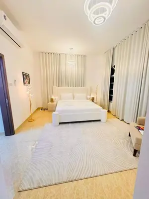 a large white bedroom with a bed and a couch at Luxe Villa Rooms in Dubai