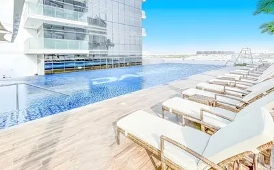 a swimming pool with lounge chairs in a building at Studio in Dubai