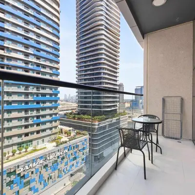 a balcony with a table and chairs and a large building at Dunya Tower in Dubai
