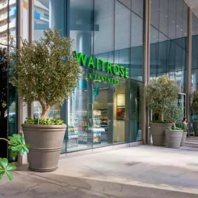 a building with three large potted trees in front of a store at Dunya Tower in Dubai