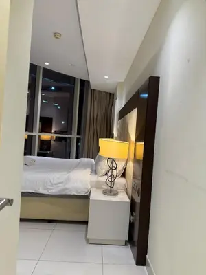 a bedroom with a bed and a lamp on a table at Spacious 2BR in DAMAC - Burj View in Dubai
