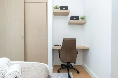 a bedroom with a desk and a chair next to a bed at PVH - Marina Gate 2 - Harmonious 2BR with Sea View in Dubai