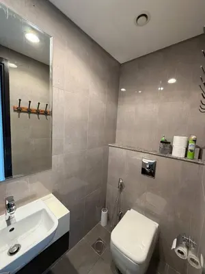 a bathroom with a white toilet and a sink at 1BR Canal Views Large Balcony Spacious BusinessBay in Dubai