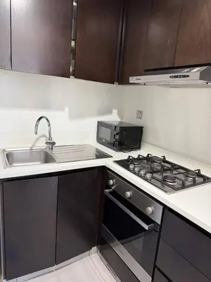 a kitchen with a stove top oven next to a sink at 1BR Canal Views Large Balcony Spacious BusinessBay in Dubai