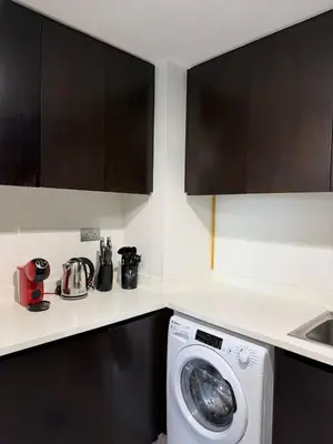a kitchen with a washing machine in a kitchen at 1BR Canal Views Large Balcony Spacious BusinessBay in Dubai