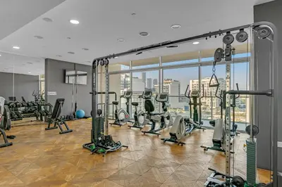 a gym with tread machines and a large window at The Fitness Suite JVC - Pool View - Zaya Hameni in Dubai