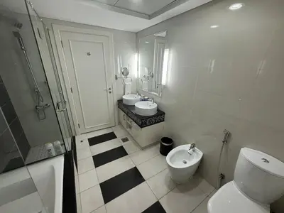 a bathroom with two sinks and a toilet and a shower at Damac Maison mall street in Dubai