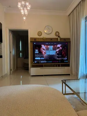 a living room with a flat screen tv on a entertainment center at Damac Maison mall street in Dubai