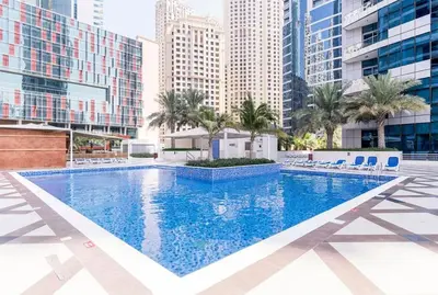 a large swimming pool in a city with tall buildings at Werova- Waterfront 1-Bedroom Apartment Furnished in Dubai