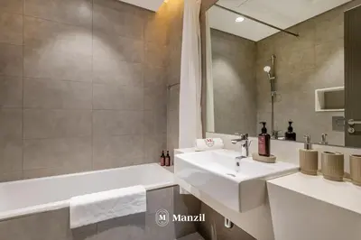 a bathroom with a tub and a sink and a bath tubermottermott at 1BR Urban Living near Downtown in District One in Dubai