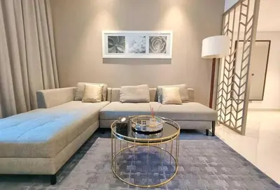 a living room with a couch and a glass table at Amazing Canal View 2 BR sweet retreat in Dubai