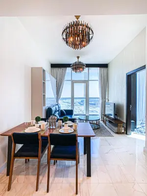 a dining room and living room with a table and chairs at Chic Urban Escape 1BR Sleeps- 4 In Bayz-18 in Dubai
