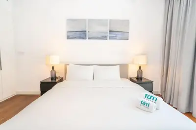 a bedroom with a large white bed with two lamps at Stylish 1BR Stay in City Walk Building 10 in Dubai