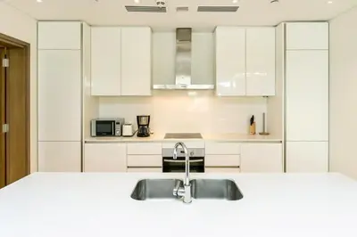a kitchen with white cabinets and a sink at Elegant 2BR with Maids Room City Walk in Dubai