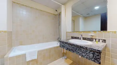 a bathroom with a sink and a tub and a mirror at Vacationer l Cozy 2 Bed l Breathtaking Sea and Ain Dubai Views in Dubai