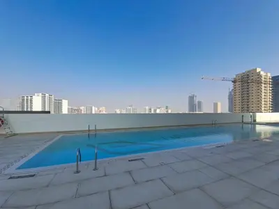 a swimming pool on the roof of a building at Vacationer l Elegant 1 Bedroom l Near to Park and Mall l JVC in Dubai