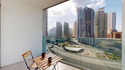 a balcony with a wooden bench and a view of a city at Vacationer l Chic Upgraded Studio l City Views l Dubai Marina in Dubai